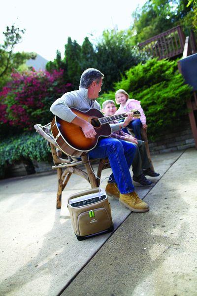 mężczyzna grający na gitarze z koncentratorem tlenu