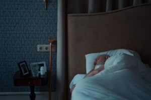 starszy mężczyzna śpiący na łóżku