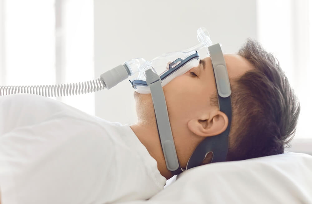Mężczyzna śpiący z aparatem CPAP – brandvital.eu Mężczyzna śpiący z aparatem CPAP – brandvital.eu